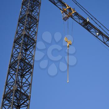 Crane fragment with hook above blue sky