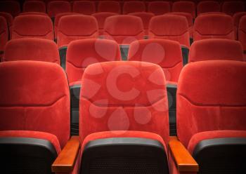 Red velvet armchairs in the empty auditorium