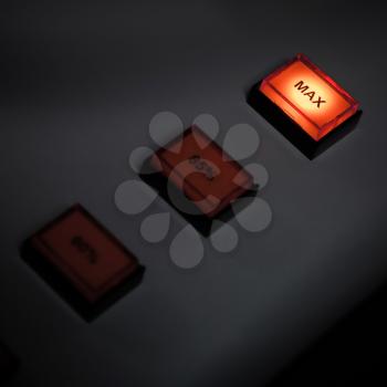 Illuminated max button on industrial power control panel. Selective focus