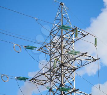 High voltage power lines and large pylon above blue sky