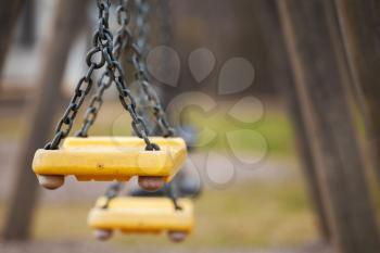 Empty yellow plastic swings on playground