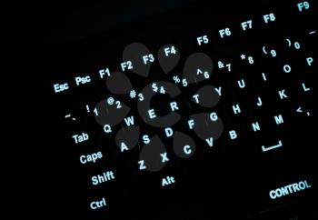 Fragment of illuminated industrial keyboard in the dark