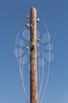 Disconnected electric wires on old wooden pylon 