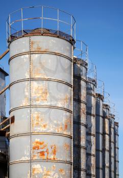 Rusted gray tall tanks on old factory