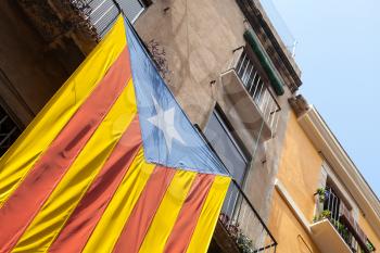 Flag of independent Catalonia hanging on facade of living house 