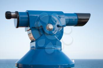 Blue paid tourist telescope on the sea coast over blue sky background