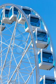 Ferris wheel over clear blue sky background, vertical photo
