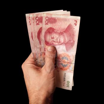 Modern Chinese 100 yuan renminbi banknotes in male hand isolated on black