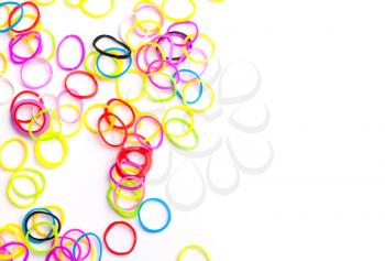 Small round colorful rubber bands for making rainbow loom bracelets isolated on white