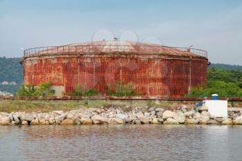 Large old rusted oil tank on the lake coast, Port of Varna, Bulgaria
