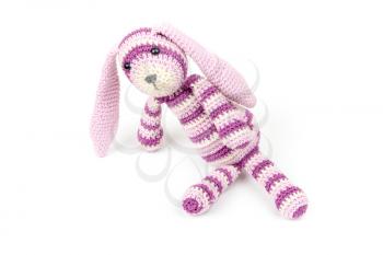 Knitted rabbit toy is sitting isolated on white background