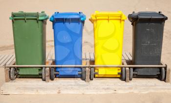 Colorful plastic containers in a row for separate garbage collection, front view