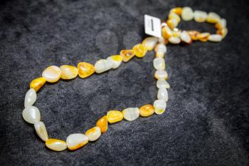 Hangzhou, China - December 2, 2014: Traditional Chinese yellow stone bead lays on black counter in gemstones shop