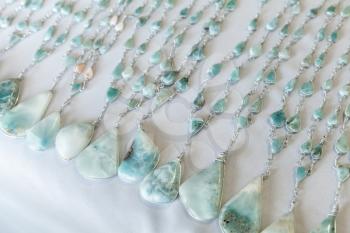 Beads of blue larimar stone lie on the counter of souvenir shop on the beach in Dominican republic