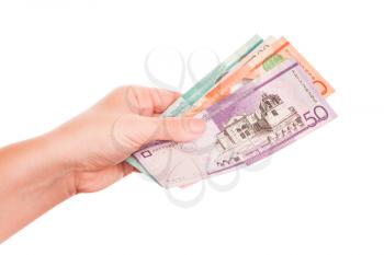 Dominican Republic money in female hand, close-up studio photo isolated on white background