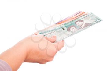 Dominican Republic money in female hand, closeup studio photo isolated on white background