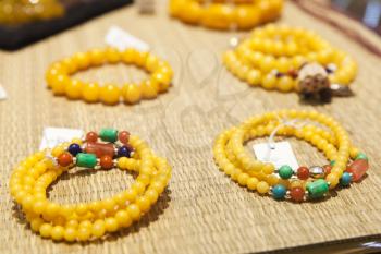 Chinese necklace made of yellow round stones lays on counter