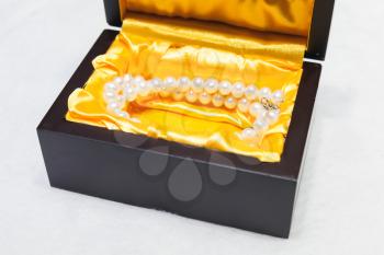 Necklace of white pearls in a gift box on a counter