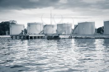 Metal oil tanks on the sea coast in Varna port, Bulgaria. Blue toned photo
