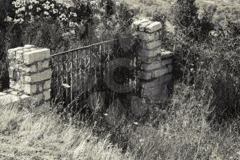 Old locked stone gate in abandoned garden. Corsica, France