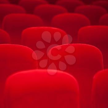 Red velvet armchairs in the empty auditorium