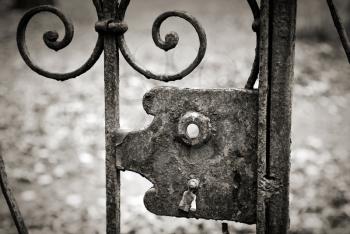 Empty old lock on the metal fence. Monochrome retro stylized photo