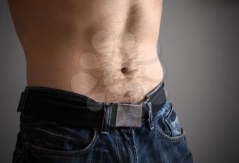 Sporty male belly with jeans. Closeup photo, shallow depth of field