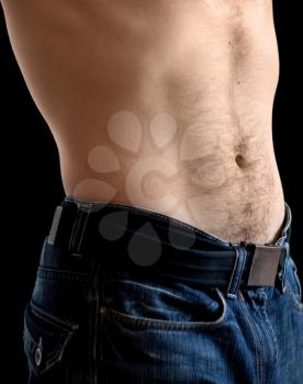 Man's belly with jeans. Closeup photo on black with shallow depth of field