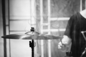 Rock music blurred background, drummer plays on cymbal. Black and white photo