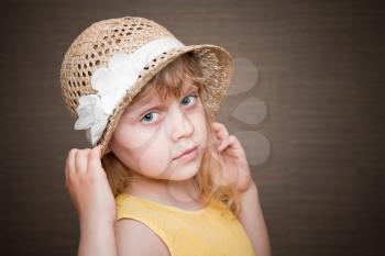 Portrait of a little blond girl with nice straw hat