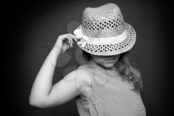 Monochrome portrait of a little blond girl with straw hat