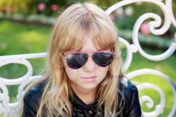 Portrait of little blond Caucasian girl in black sunglasses