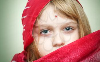 Closeup portrait of little blond girl in red eastern Clothing