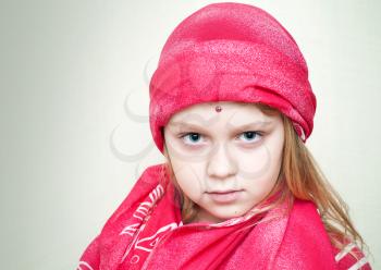 Closeup portrait of little beautiful blond girl in red eastern Clothing