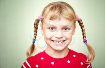 Closeup portrait of smiling little blond girl with pigtails