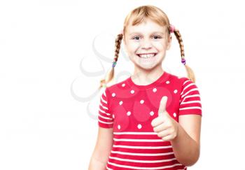 Portrait on white background. Little blond girl in red with pigtails smiles and thumb up