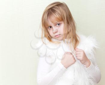 Little blond girl in white fluffy fur vest