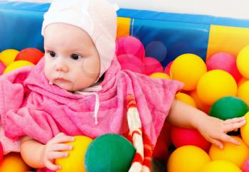 Little baby girl plays with colorful balls