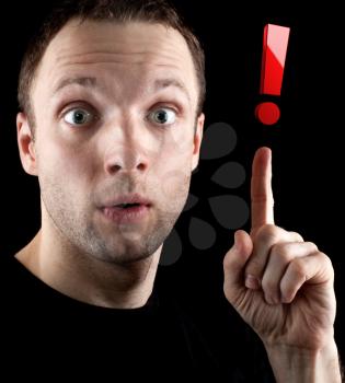 Surprised man shows red exclamation mark  isolated on black background