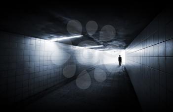 Man goes on underground passage with neon lights and glowing end