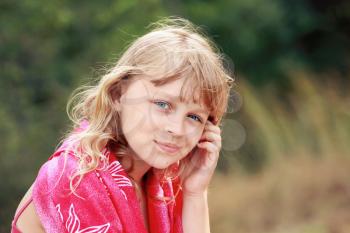 Outdoor summer portrait of Little blond Caucasian girl in red shawl