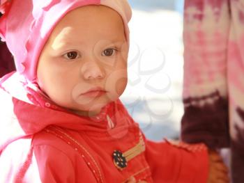 Little baby girl in red, closeup outdoor portrait