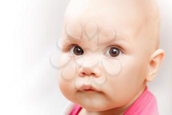 Little brown eyed Caucasian baby girl closeup studio portrait on white background