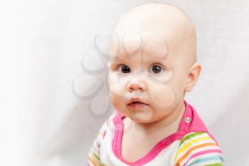 Little brown eyed Caucasian baby girl closeup studio portrait