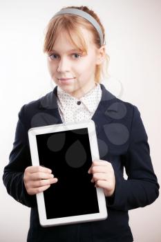 Little blond girl holds tablet device on white background