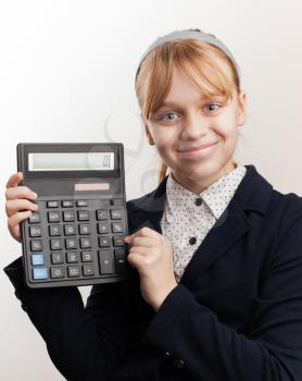 Little blond smiling schoolgirl with calculator above white