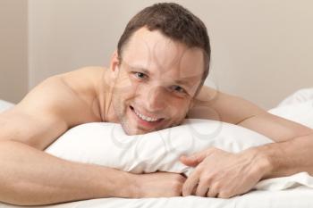 Portrait of pleased Young Caucasian man in bed