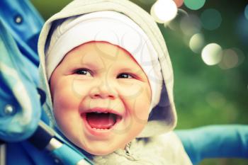 Little baby girl laughs in pram on the walk. Instagram toned effect