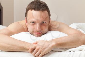 Portrait of smiling handsome Young Caucasian man in bed
