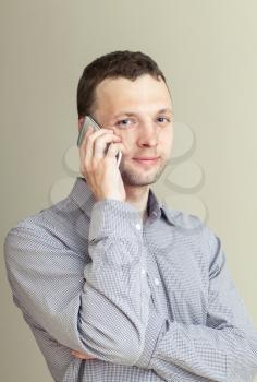 Young Caucasian Man with mobile phone, casual studio portrait